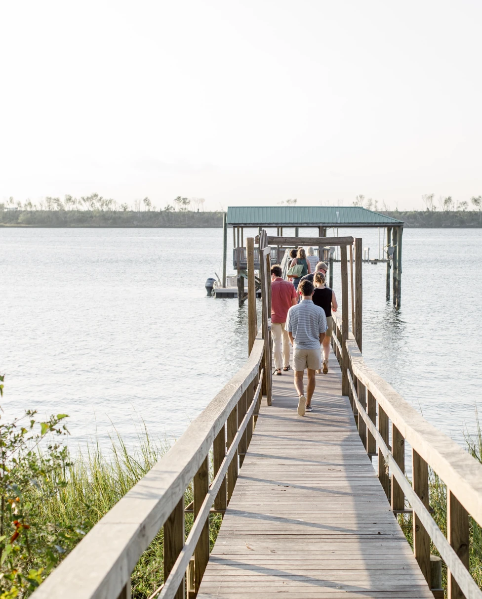 A small bridge on a beach going into water.