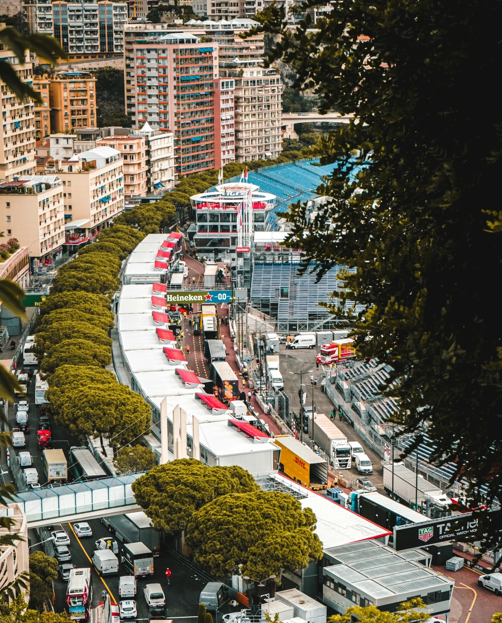 An aerial view of Monaco surrounded by bustling cars, buildings and tents preparing for the race.