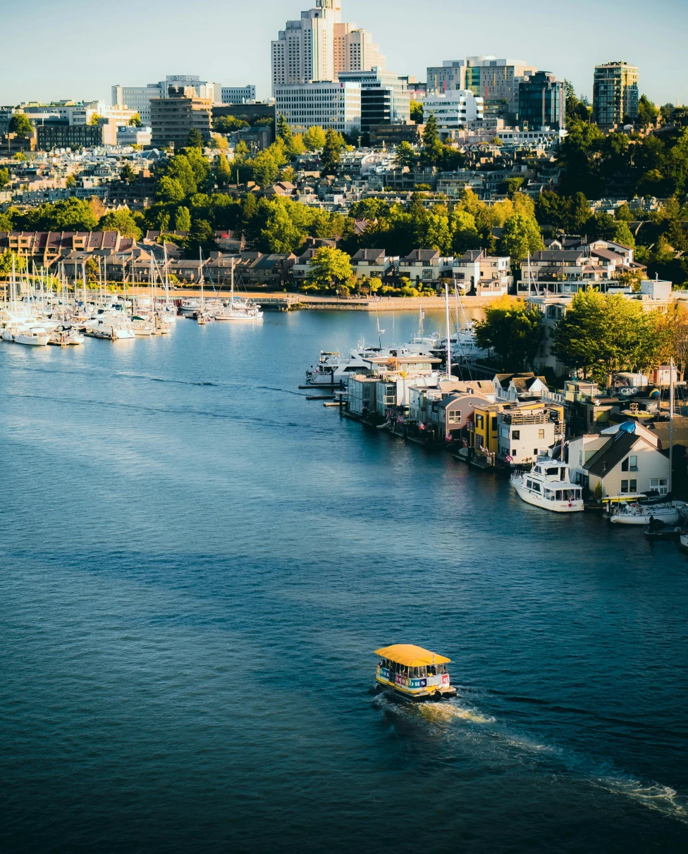 A picture of a round black and white analog clock in the middle of the street.