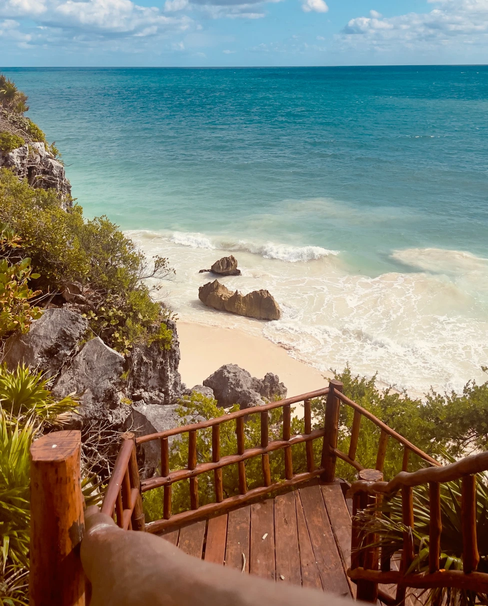 stairs leading down to the beach with ocean in the background