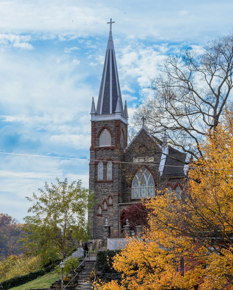 A church with a tree with autumn leaves.