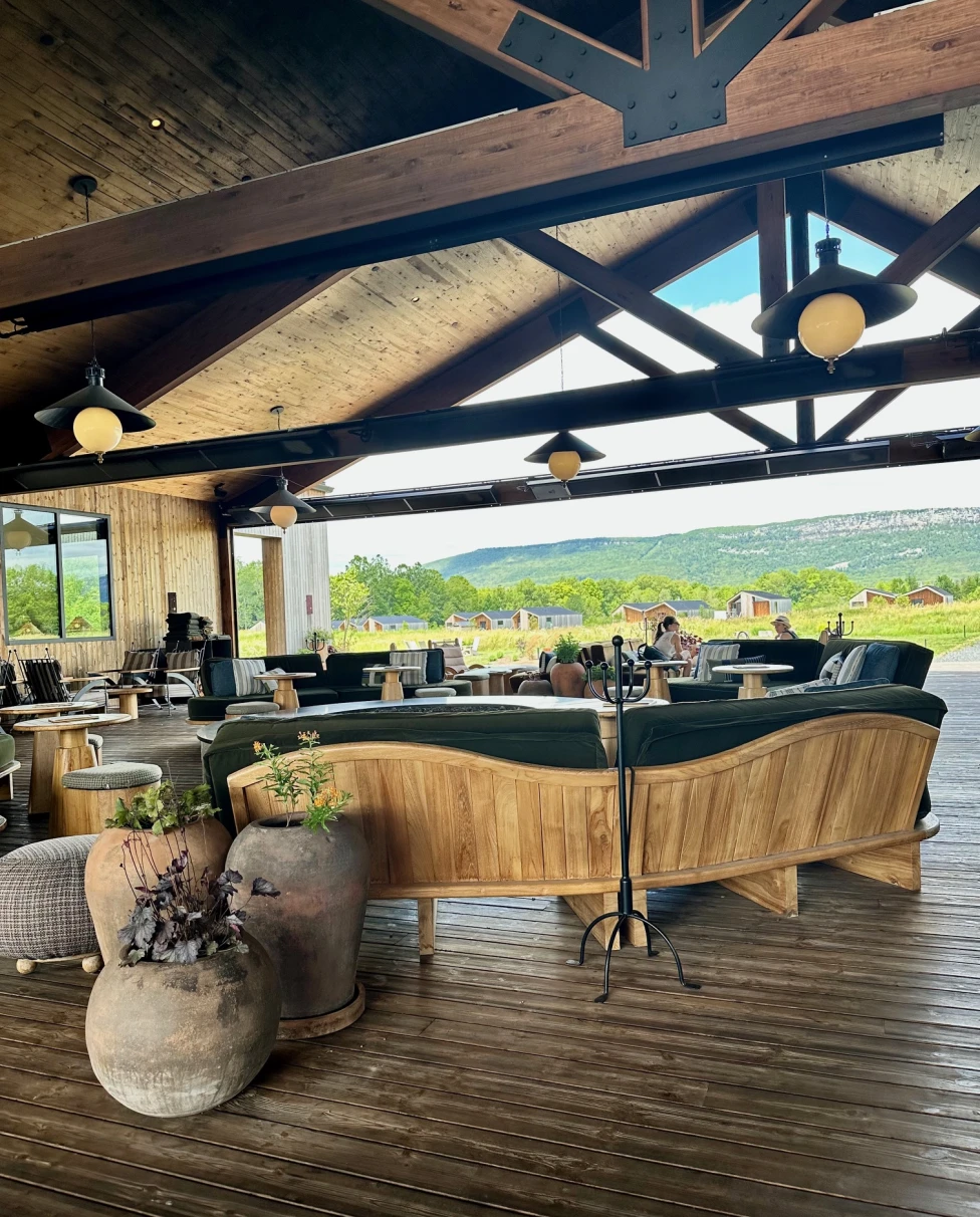 An open-air cabin space decorated with cement plant pots and wooden furniture