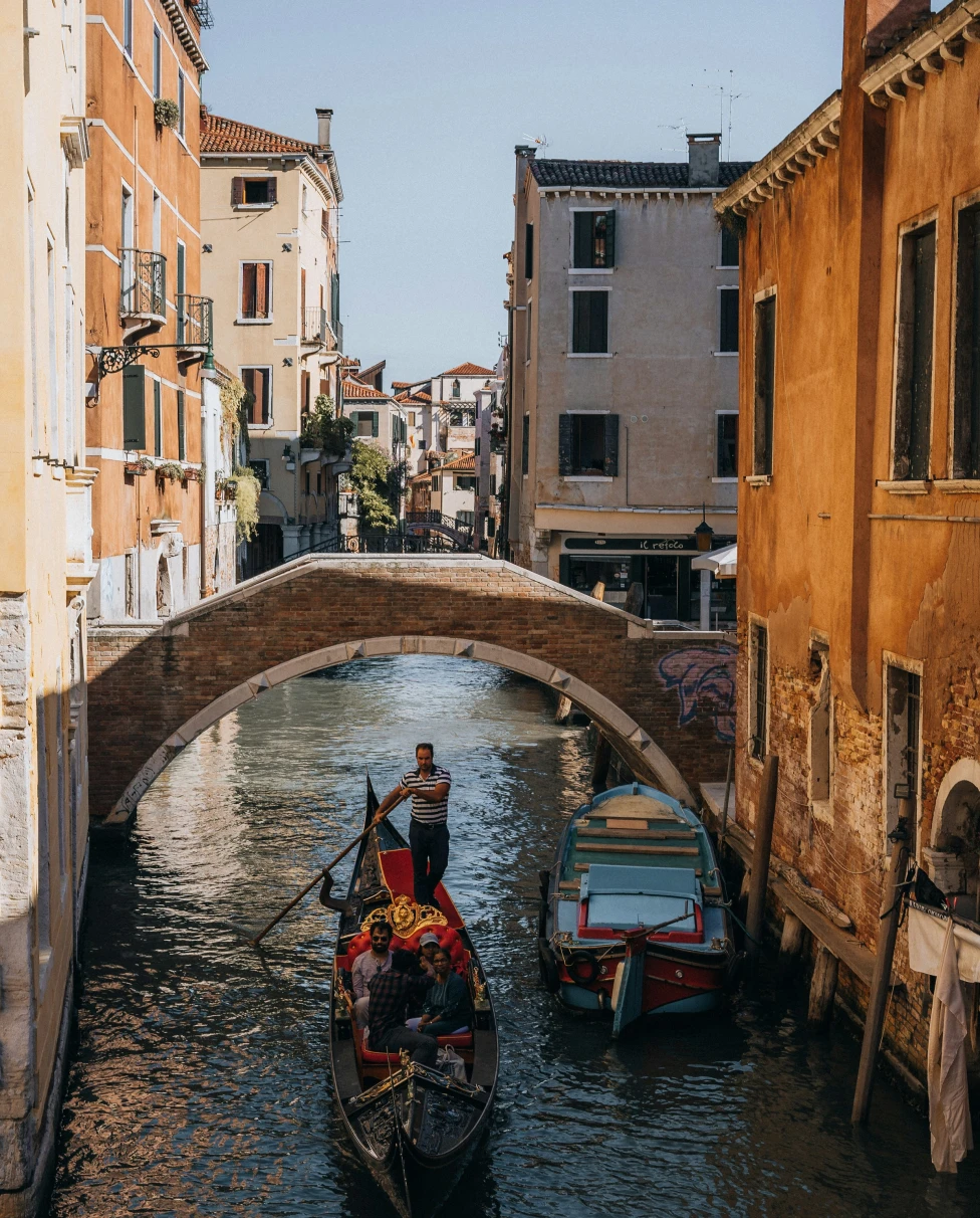 A man riding a gondola at the Venice canal.