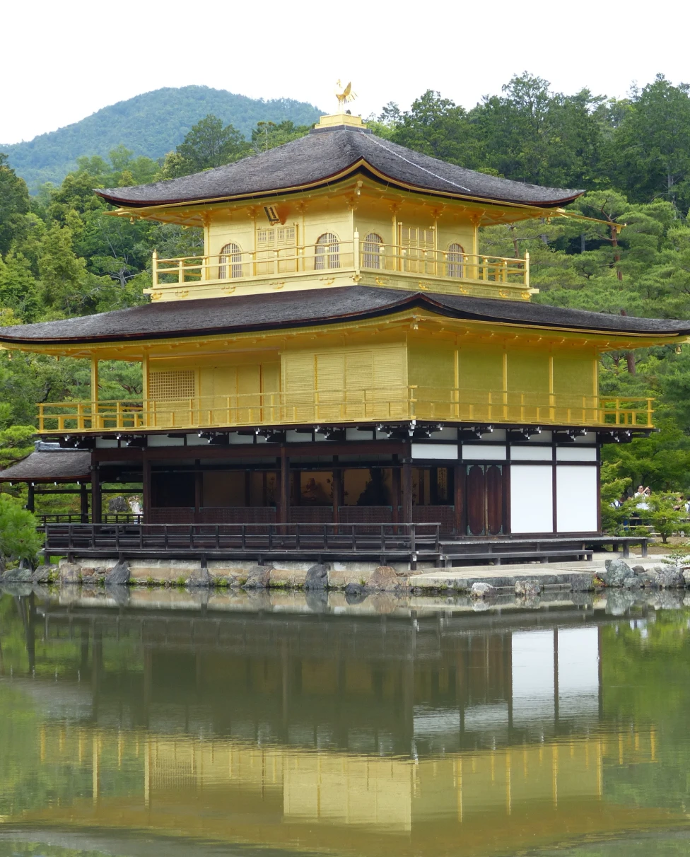 A yellow-painted pavilion in the water next to the shore