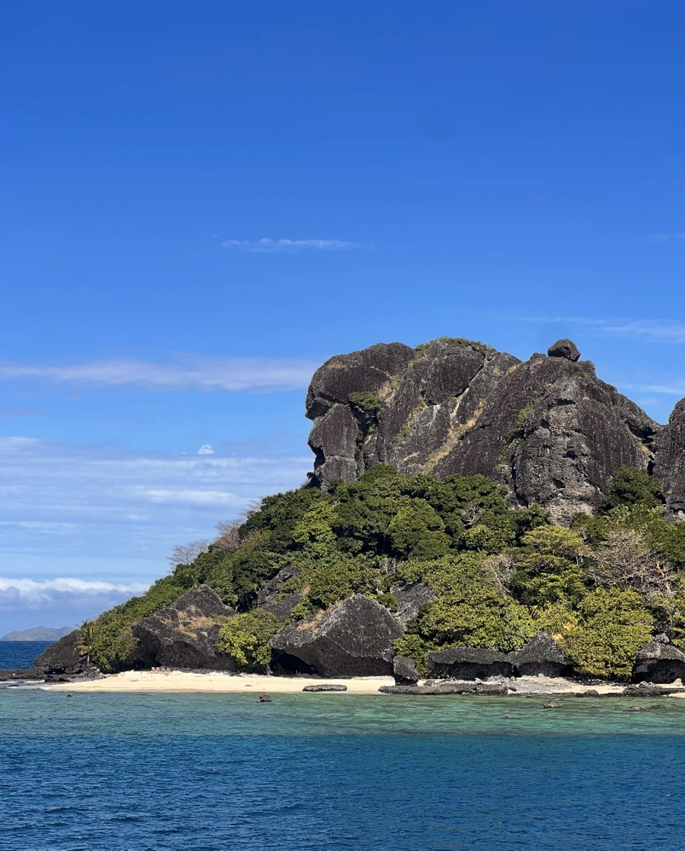 An ocean with a rocky hill on an island.