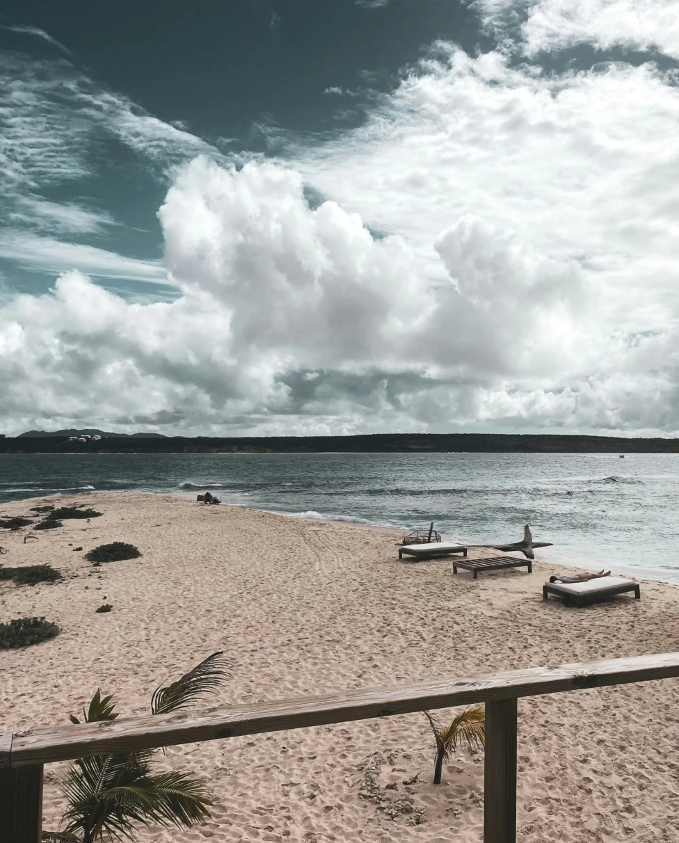 Beach chairs on beach on a partly cloudy day.