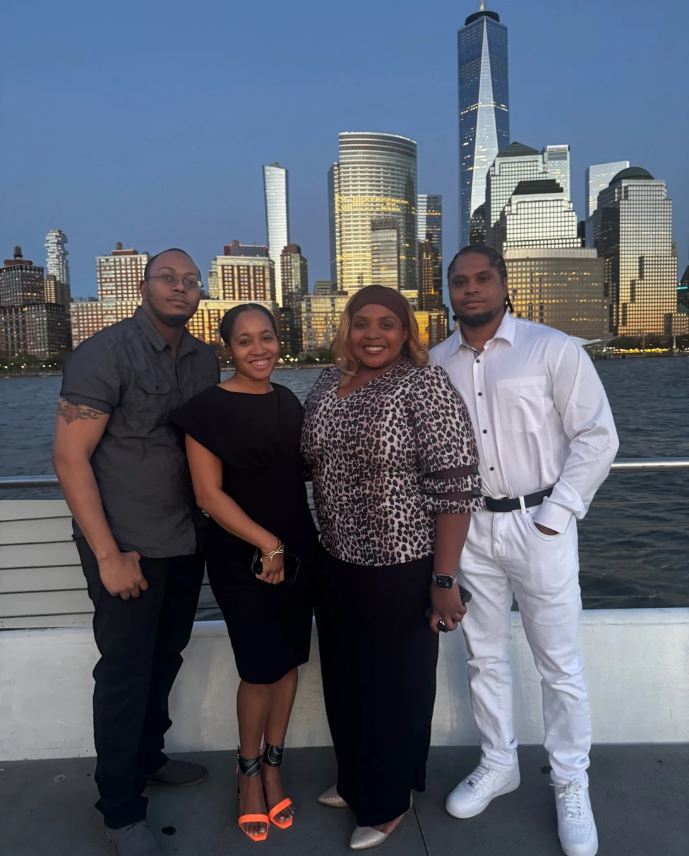 A group of people standing with a city view at night.