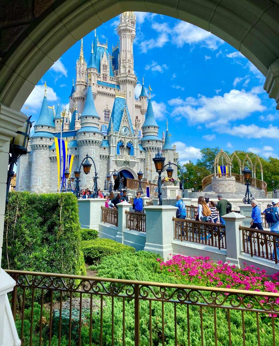 A picture of the blue-and-white Cinderella castle through an arch.