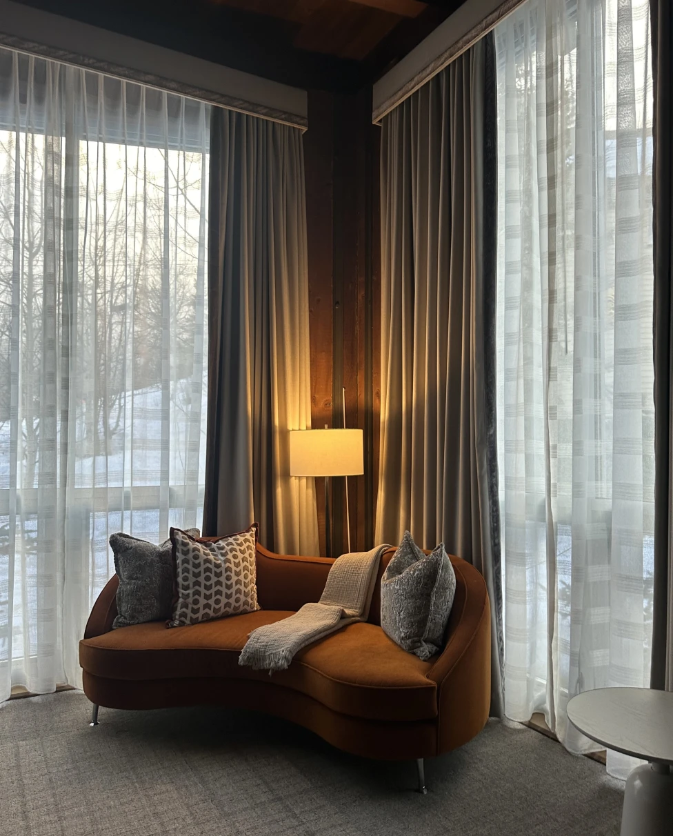 A cozy corner of a room with a lamp and dark orange corner sofa in Aspen in the fall.