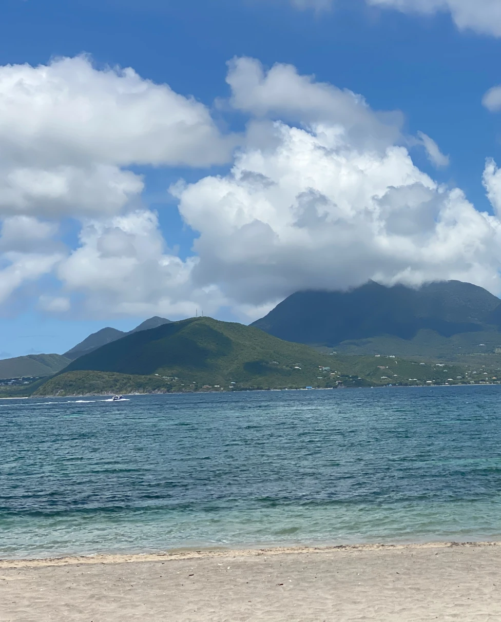View from the beach of a mountain in the distance on a cloudy day