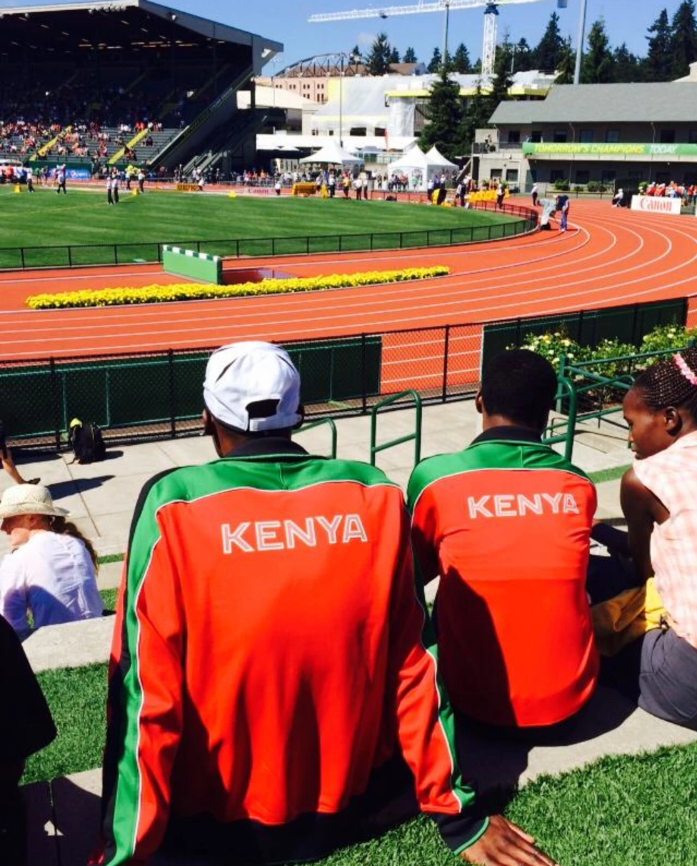 A track field with spectators watching wearing Kenya jerseys.