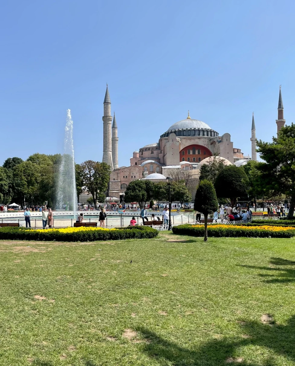 A garden with fountain and a mosque in the background.