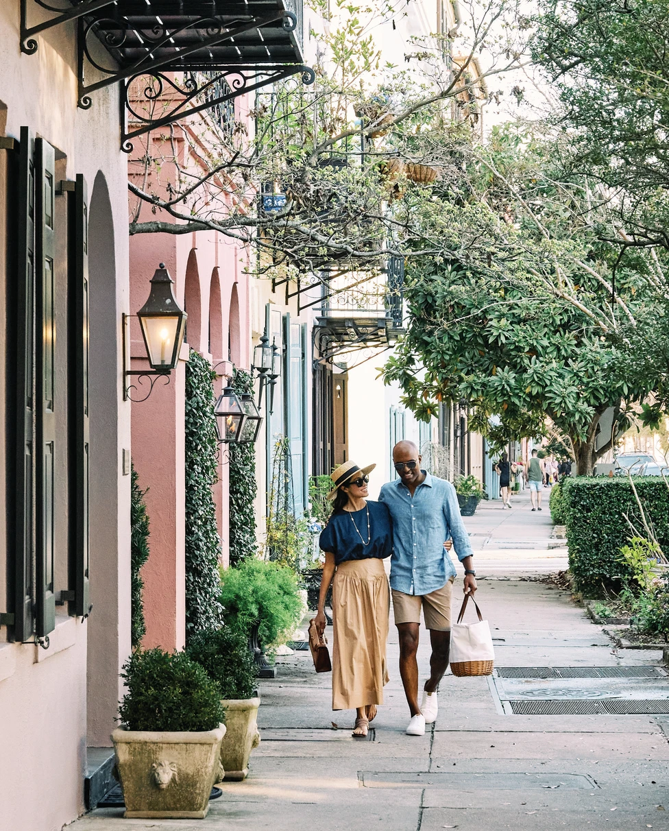 two people walking next to colorful buildings during daytime