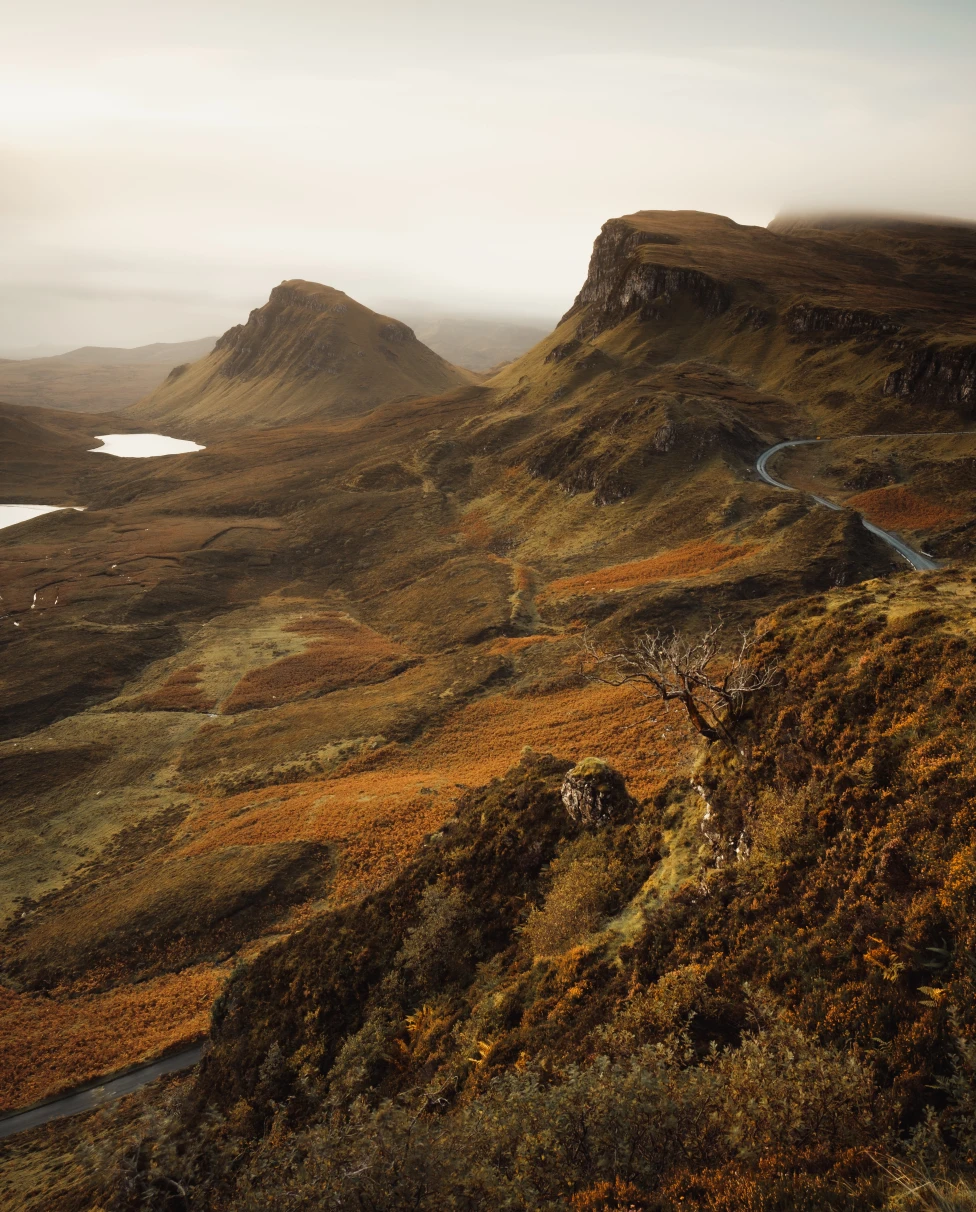 A Scottish countryside featuring hills and cliffs in fog.