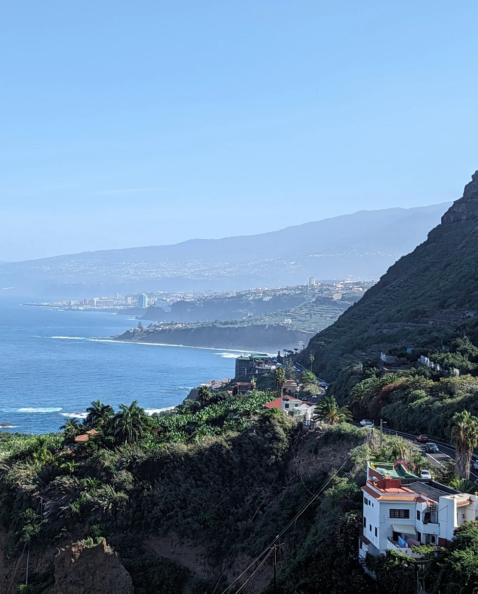 View of Tenerife Coast with buildings in green hills and the water beyond