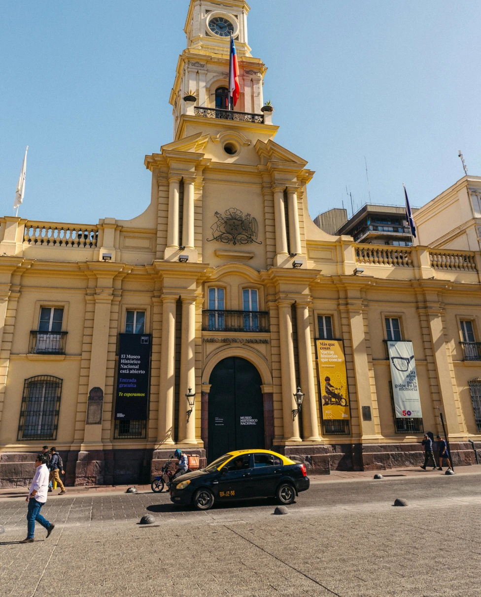 The exterior of the Museum of National History of Chile in Santiago, Chile, a yellow building with a tall central tower.