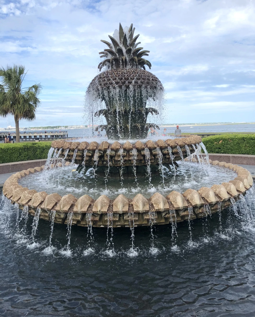 A large water fountain shaped like a pineapple during the daytime
