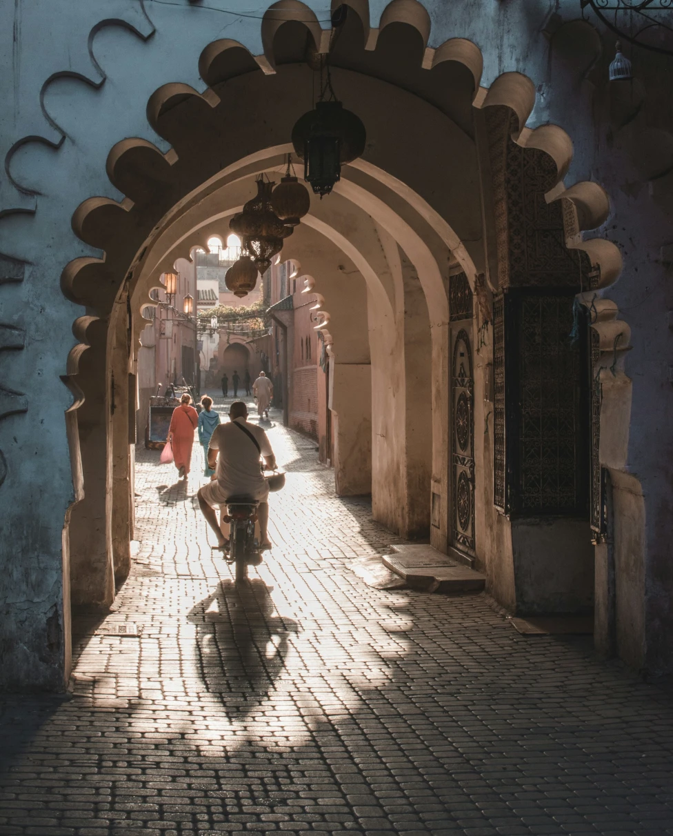 Ornate tunnel in a Marrakesh street with a man on a bike