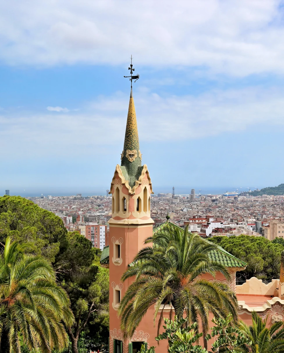 large steeple next to trees with city in background