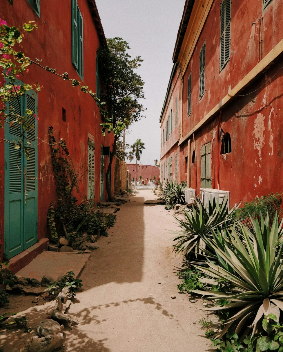 An alley between 2 red storey houses in Goree, Dakar, Senegal.