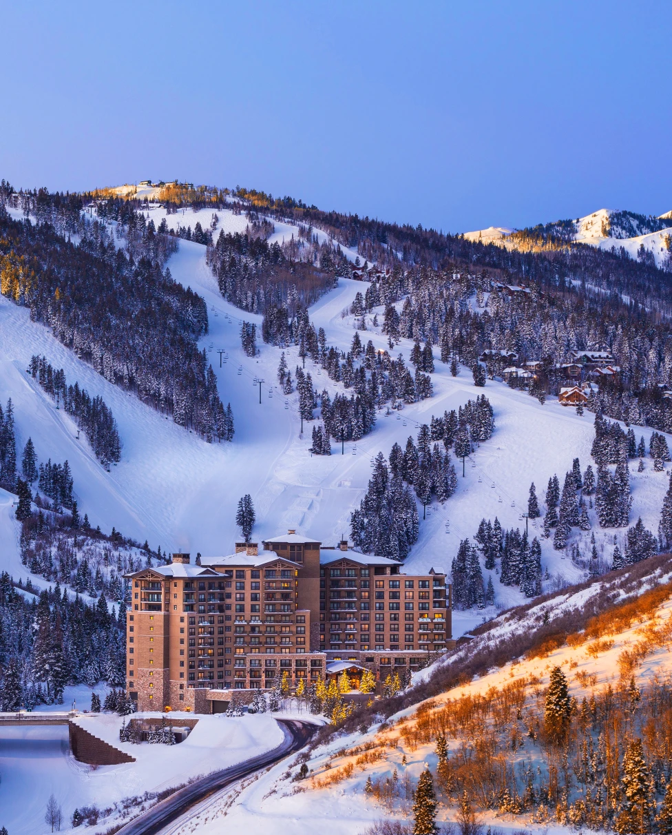 lodge next to snowy mountain with ski slopes
