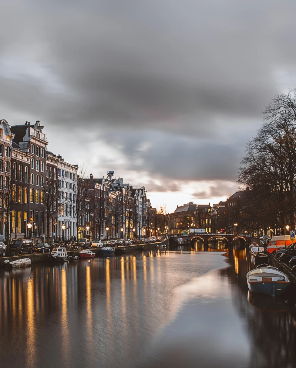 A lake with boats and city buildings on the side.