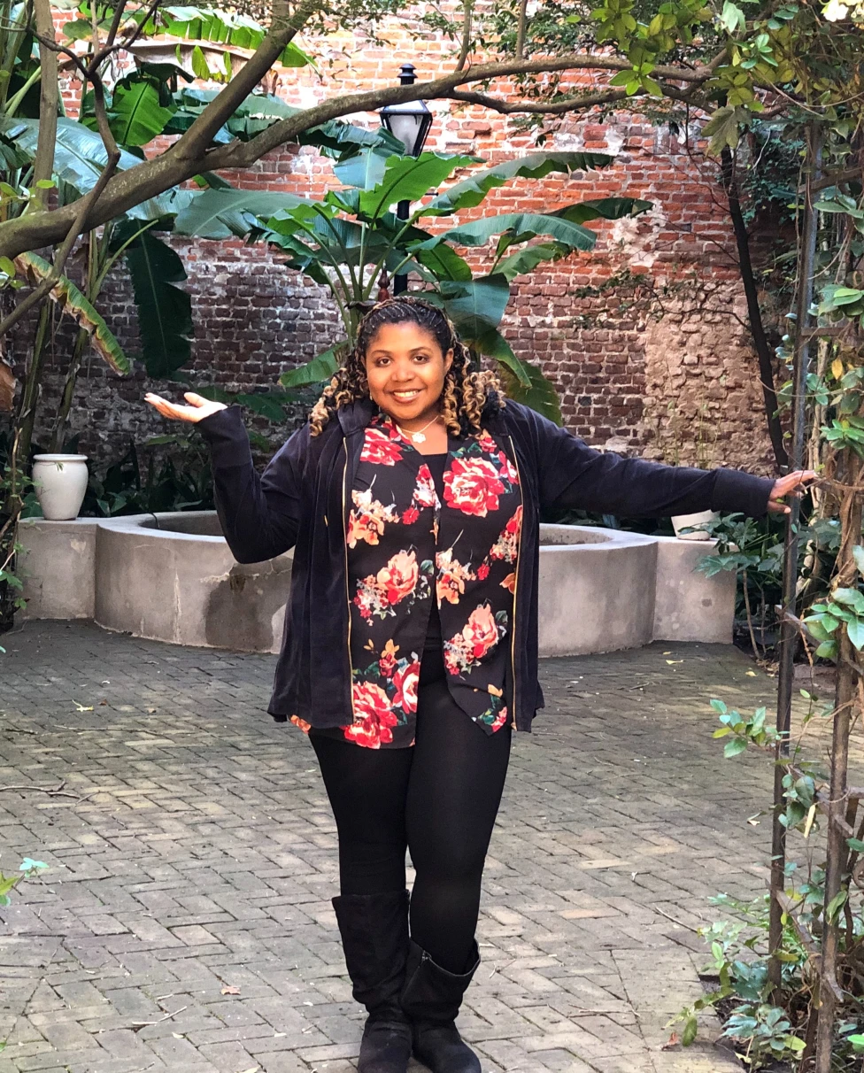 Advisor posing in a courtyard area
