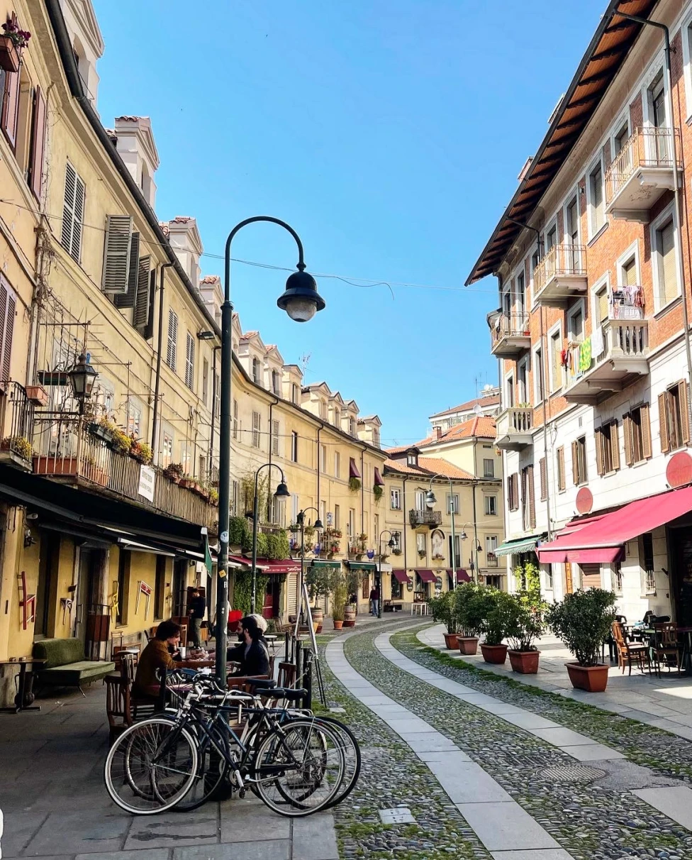 Street view of historical buildings winding along a cobbled street on a clear day.