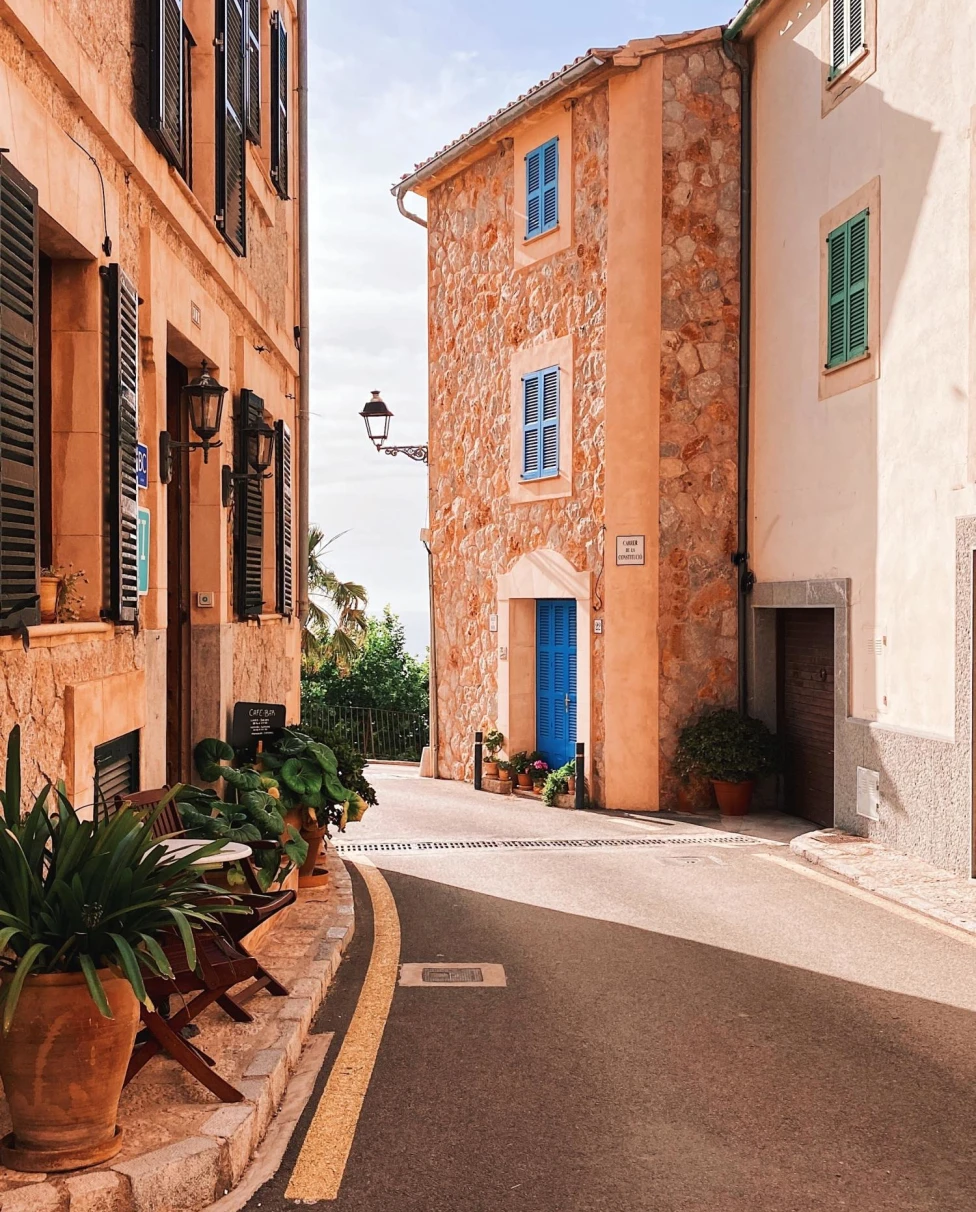 Quiet street in Mallorca heading towards ocean on sunny day.