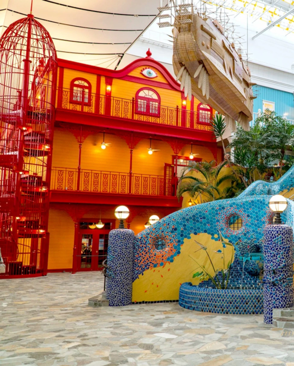 The interior of the Ghibli Park Japan, with fake colorful buildings and a stone staircase.