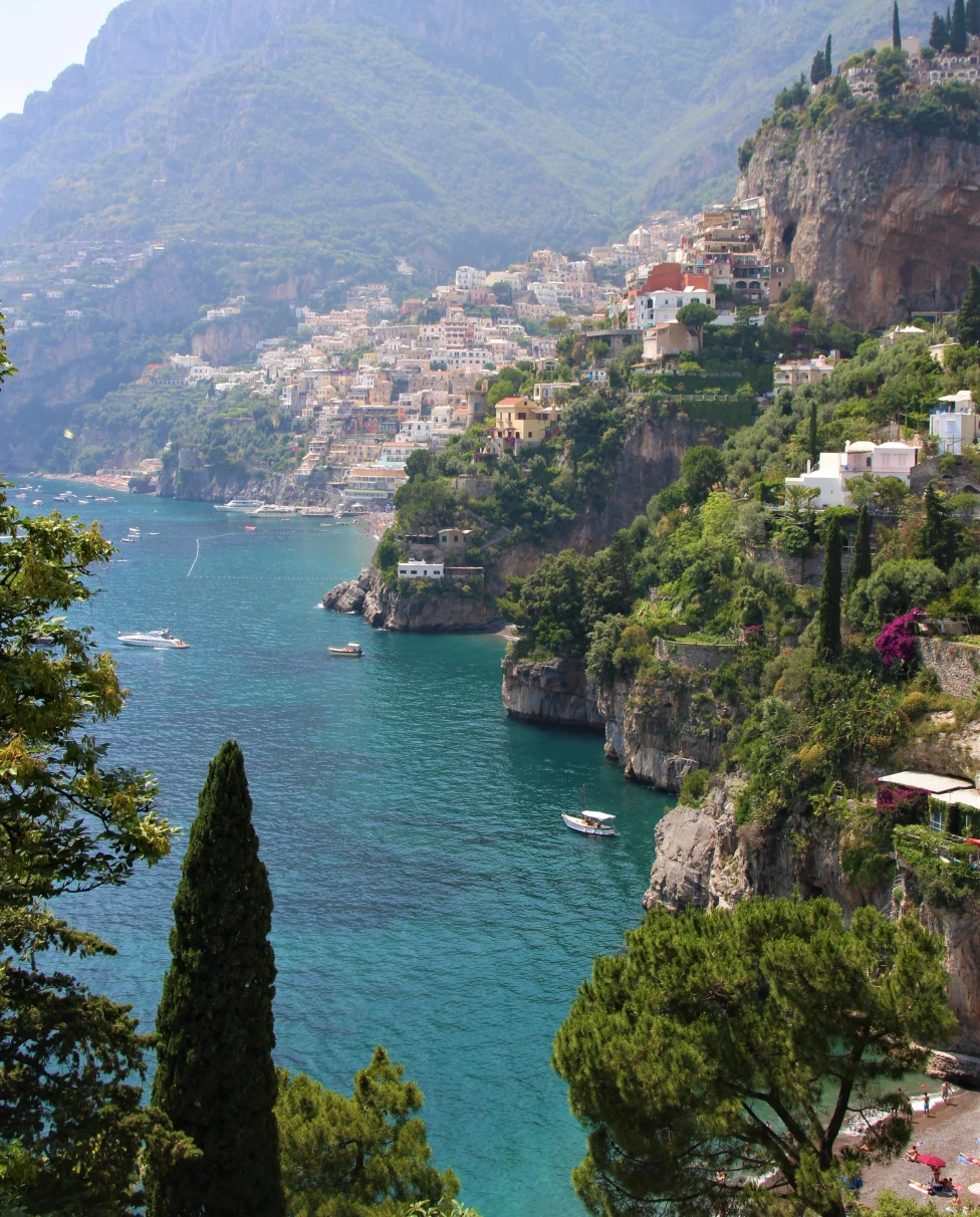 body of water next to cliff with houses during daytime