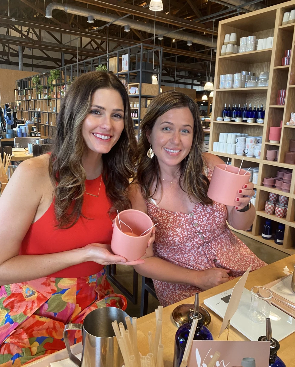 Two girls holding pink cups.