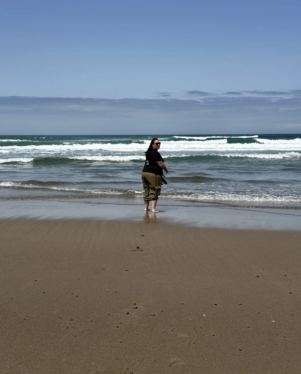 Woman on a beach with small surf.