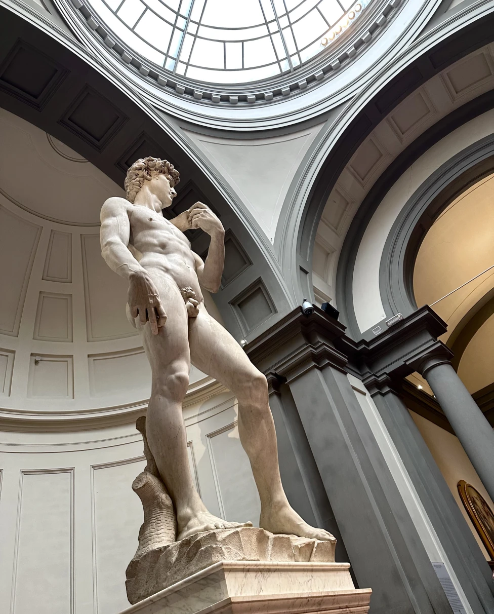 Statue of a naked man inside a museum.