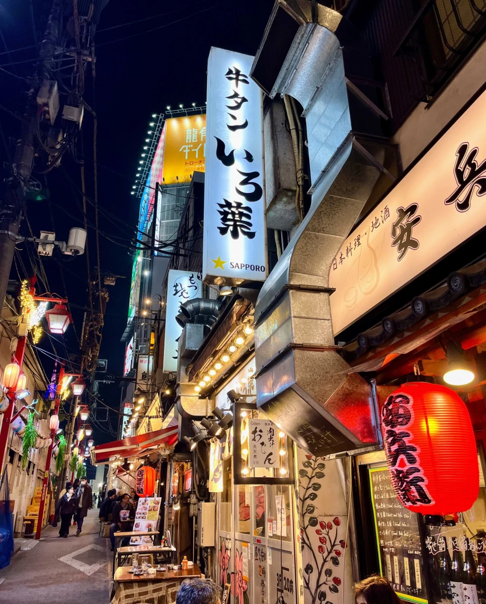 Street with well lit shops at night.