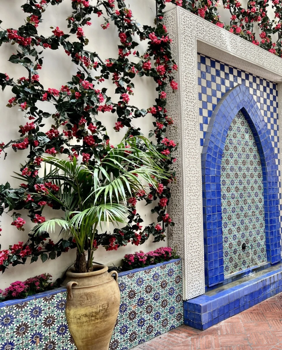 A car parked in the driveway of a decorated wall