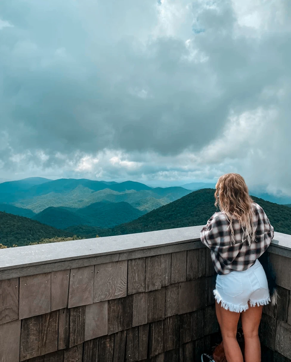 Advisor standing on a viewing platform over looking a mountain range and an overcast sky at Looking at Brasstown Bald.