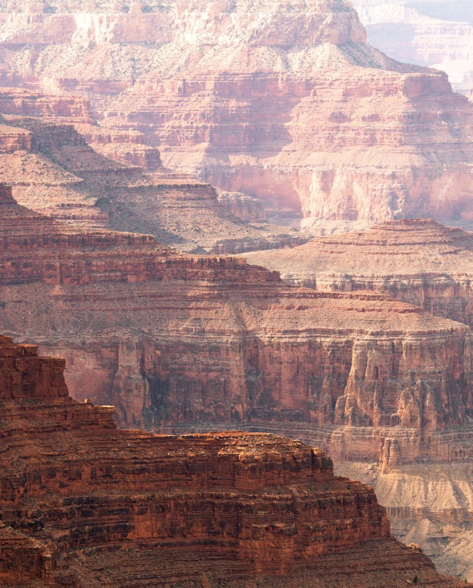 Endless layered rock formations in the Grand Canyon on a bright day.