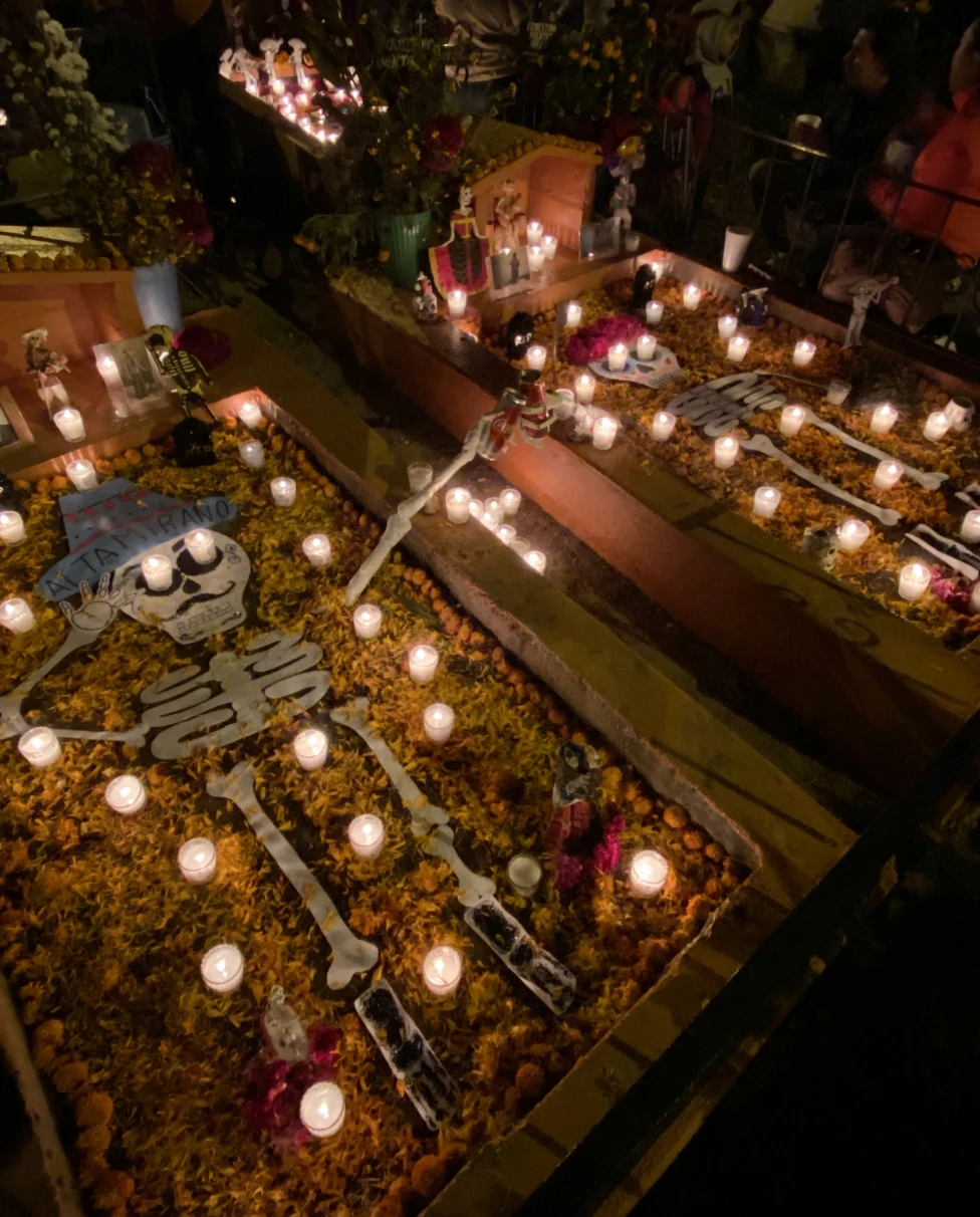 Two fake skeletons laying in a float in a dark, candle-lit room