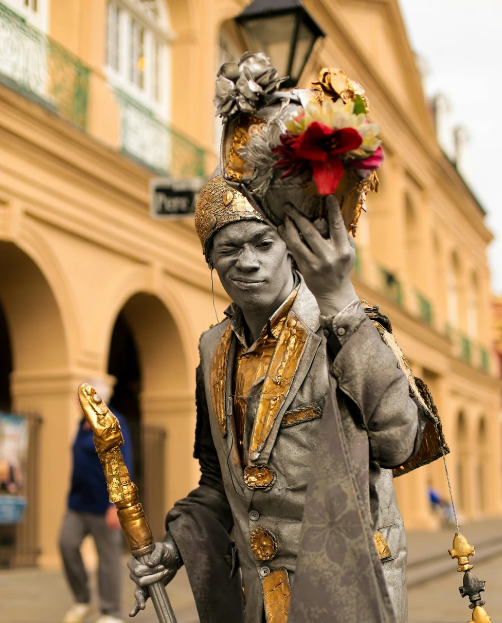 A person posing as a statue holding a bouquet of flowers