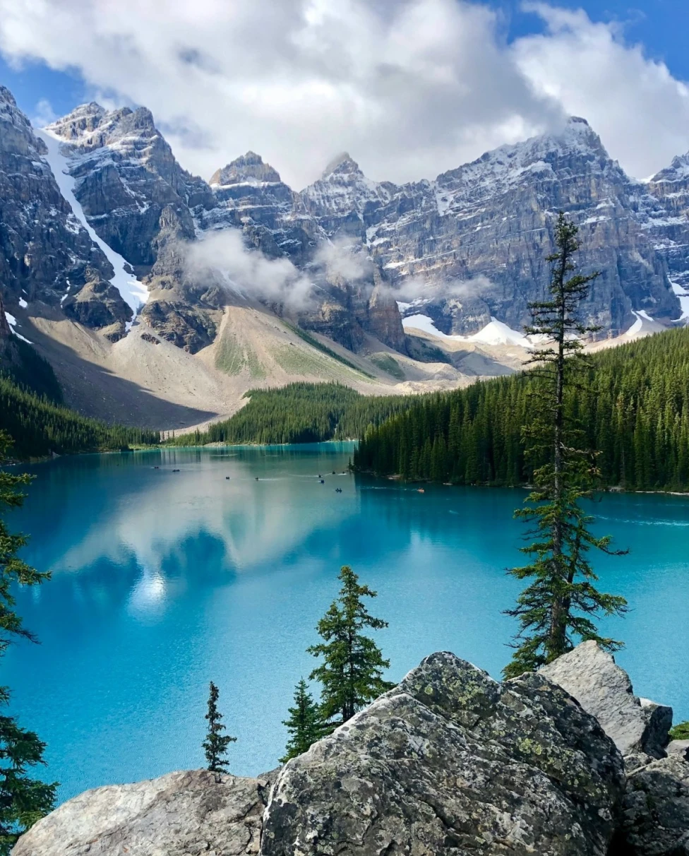 A blue lake surrounded by mountains and trees.