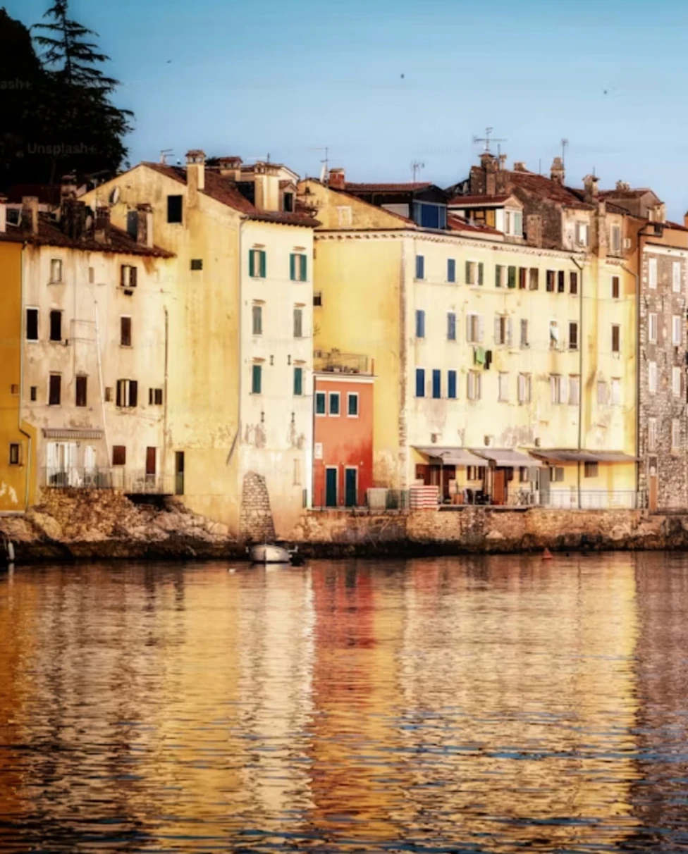 A rowboat on a body of water at sunset with hills in the distance.