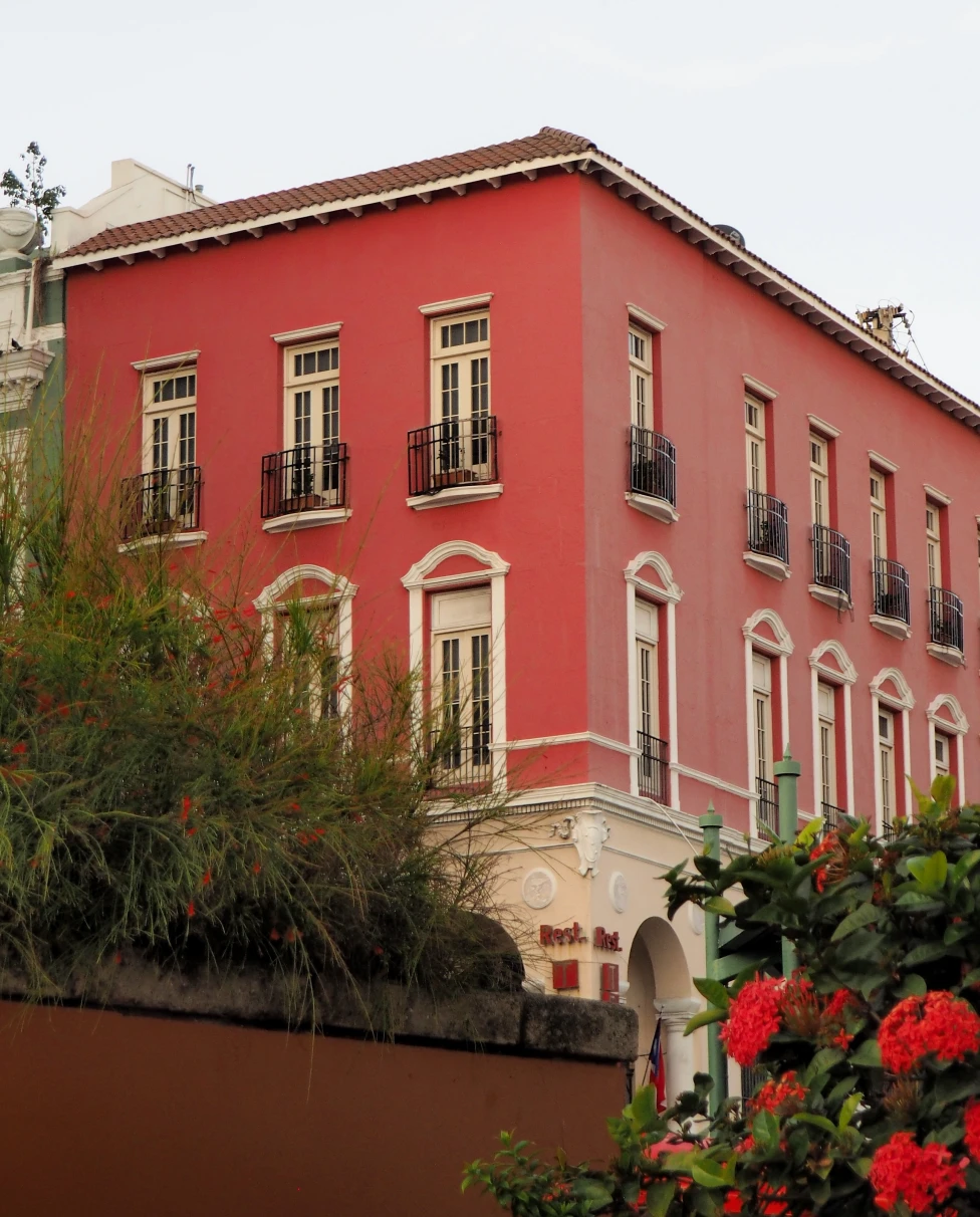 A red house flanked by tropical fauna and flowers in Puerto Rico.