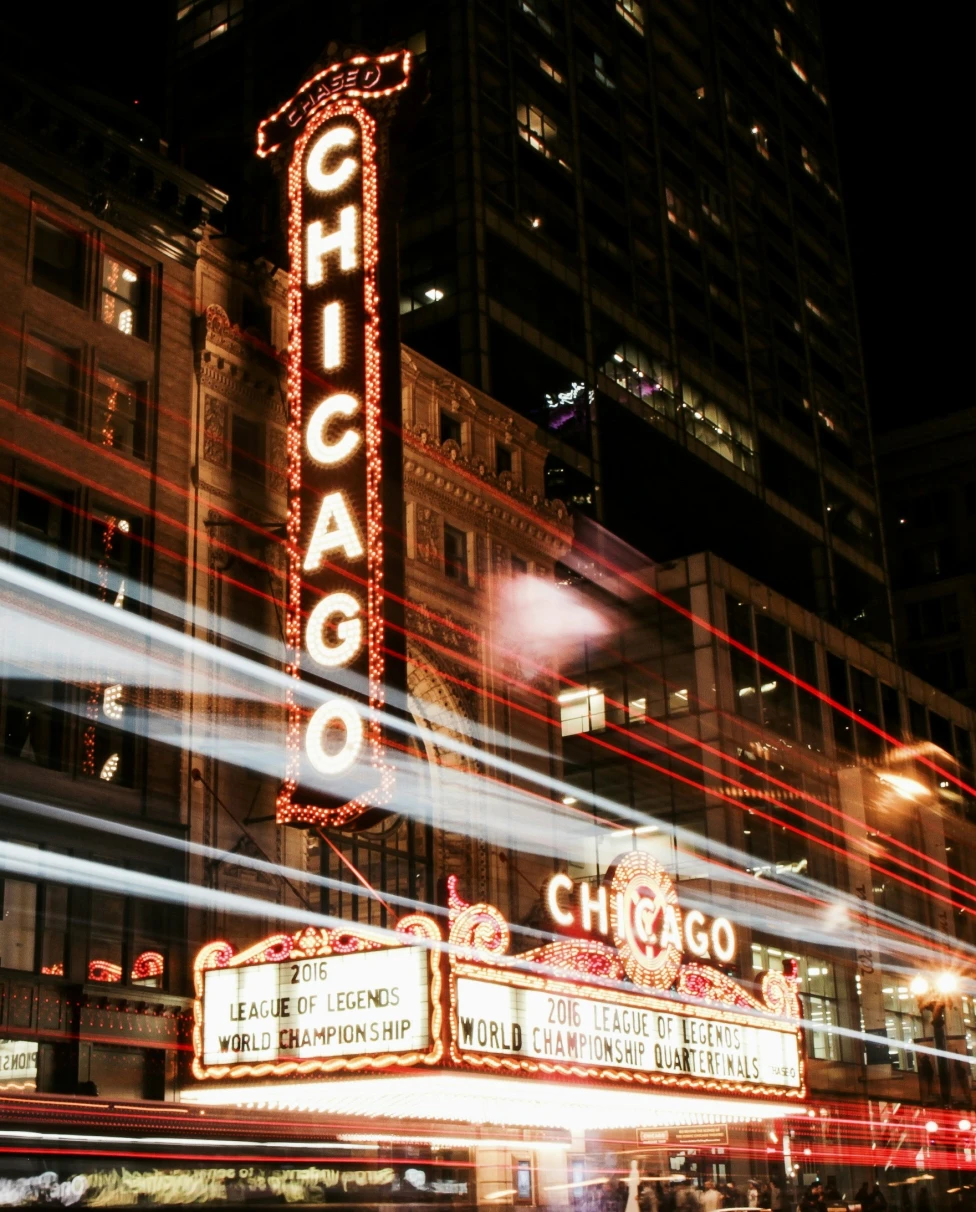 A time-lapse photo of the Chicago Theater at night.