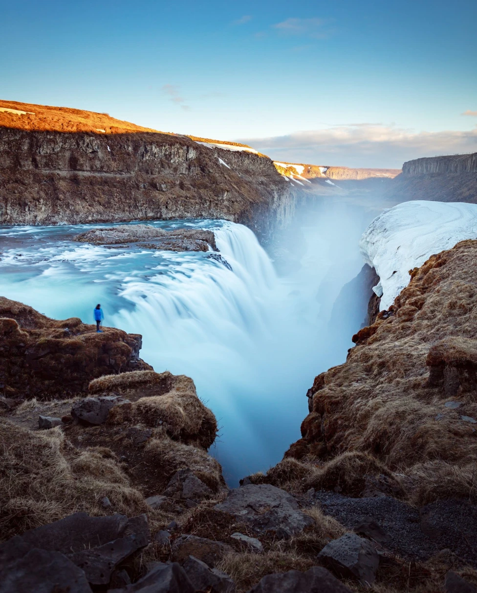 An aerial view of the waterfalls near a cliff during daytime