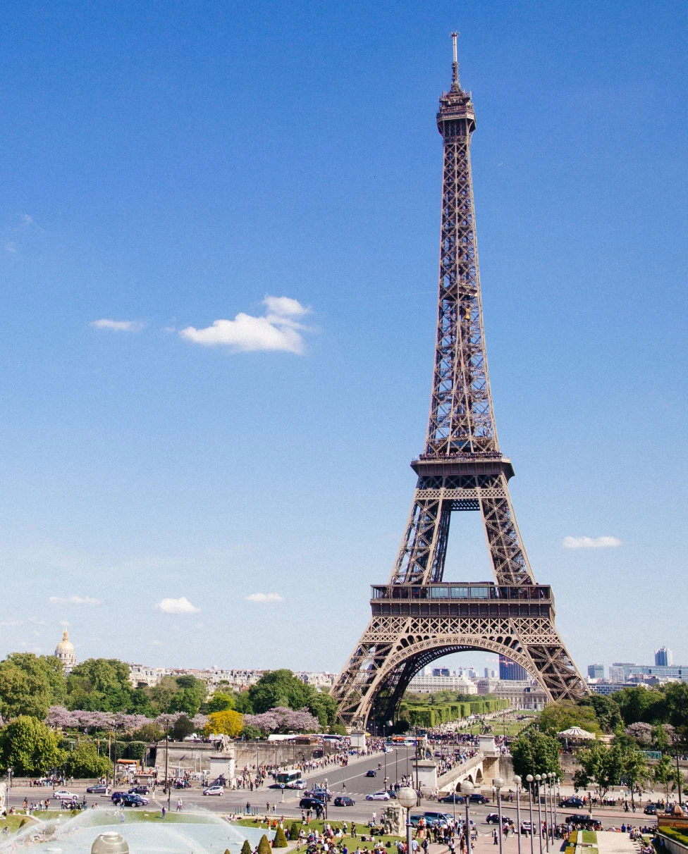 Eiffel tower with blue sky and green trees in Paris France