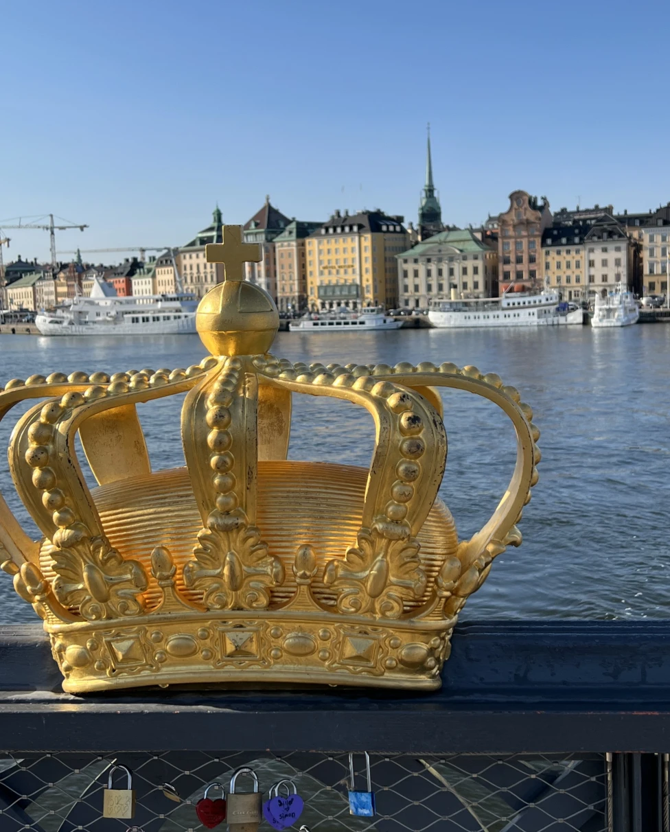 Statue of a golden crown on a bridge.