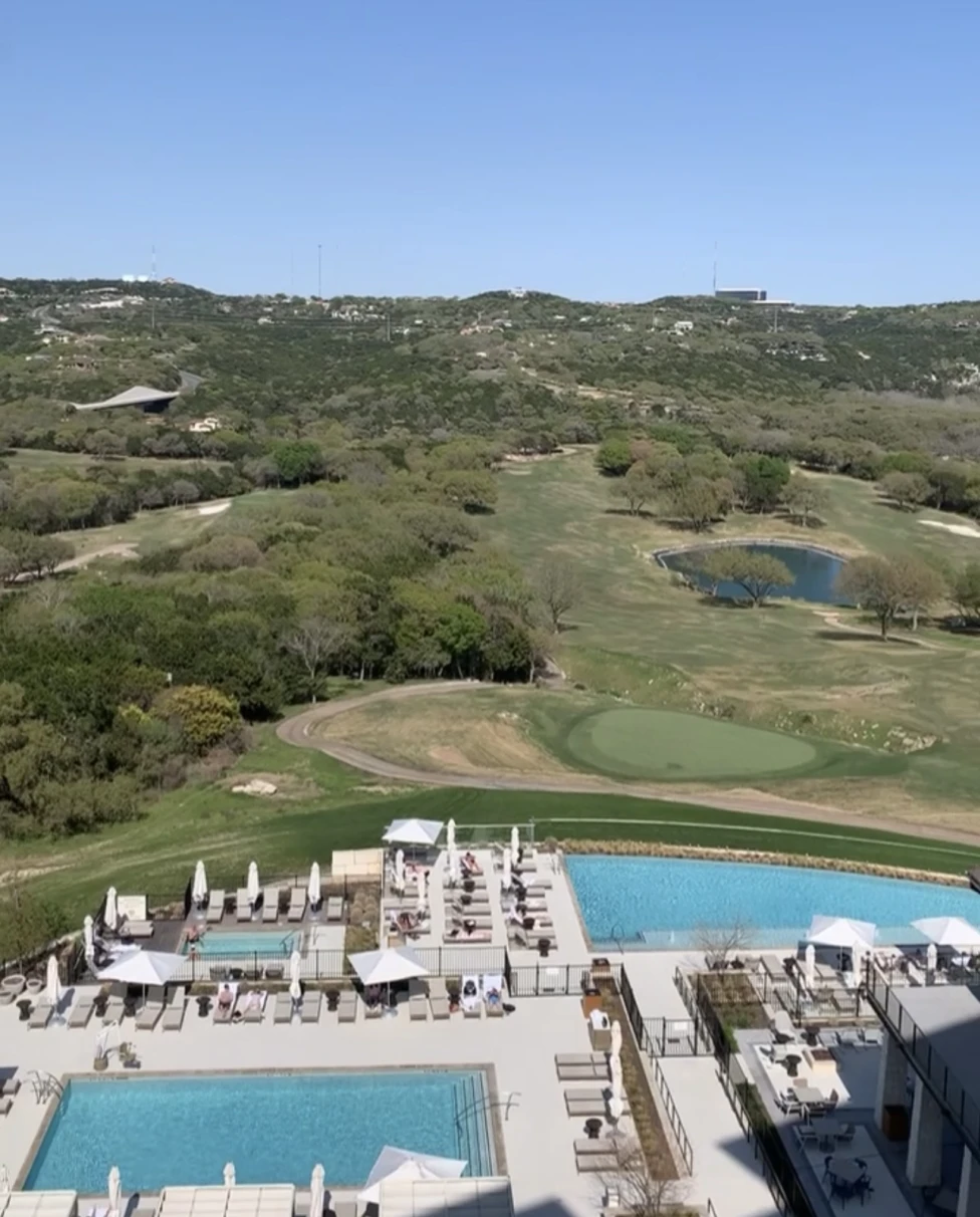 A resort pool area with a valley in the distance during the daytime