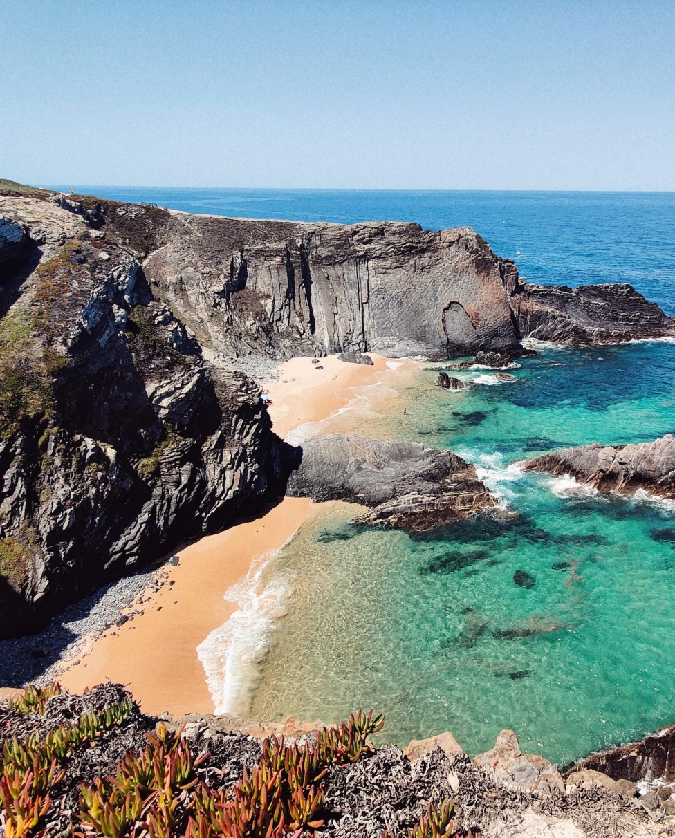 blue waters next to rocky coastline during daytime