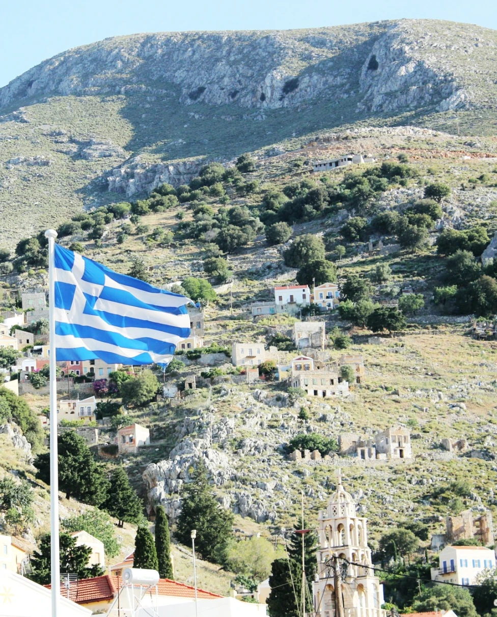 country side with Greece flag waving
